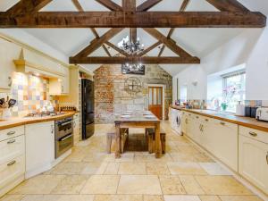 a large kitchen with a wooden table in it at 3 Bed in Longhoughton 88231 in Long Houghton
