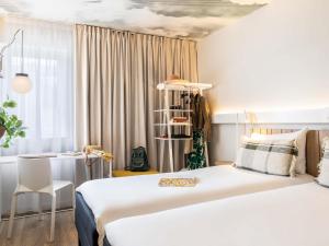 a hotel room with a bed and a desk at ibis Maine Montparnasse in Paris