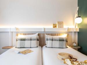 a bedroom with a bed with two pillows at ibis Maine Montparnasse in Paris +32 photos