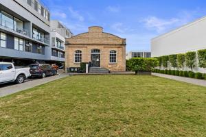 un gran patio frente a un edificio de ladrillo en Victoria Park Haven w carpark, spa, pool and gym, en Auckland