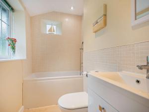 a bathroom with a toilet and a tub and a sink at 2 Bed in Salthouse NCC15 in Salthouse +8 photos