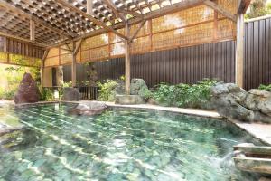 a pool of water with rocks in a building at Ooedo Onsen Monogatari Premium Ito Hotel New Okabe in Ito