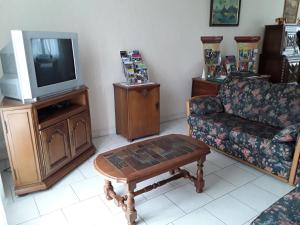 a living room with a tv and a couch and a coffee table at Évasion en Berry: Maison proche Voie Verte, Château et Nature - idéal familles et pêcheurs - FR-1-591-55 in Chabenet