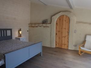 a bedroom with a bed and a wooden door at Maison de vacances rénovée, entre nature et ville, proche du Puy-en-Velay - FR-1-582-321 in Arsac-en-Velay
