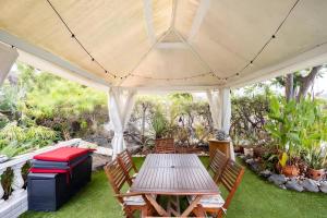 a table and chairs under a white gazebo at Modern Panoramic Villa with Pool & Terrace in Puerto de la Cruz