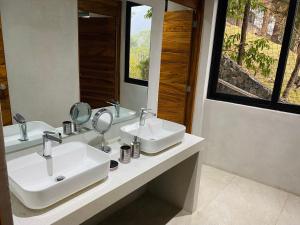 a bathroom with two sinks and a mirror at Casa Verapaz in Santa Catarina Palopó