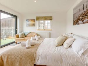 a white bedroom with a large bed and a couch at 3 Bed in Bideford 79552 in Bideford