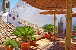a patio with a bench and an umbrella and plants at Casa Pinto in Monsaraz