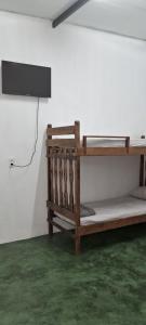 a room with a bunk bed and a television on a wall at Recanto Morada do verde in Delfinópolis +14 photos