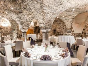 a dining room with white tables and chairs at Novotel Gent Centrum in Ghent