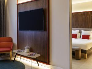 Una habitación de hotel con una cama y un televisor. en Novotel Madrid City Las Ventas, en Madrid 101 fotos más