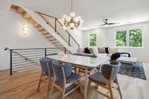 a living room with a table and chairs and a staircase at Luxury Build - King Beds - Minutes to Uptown in Charlotte