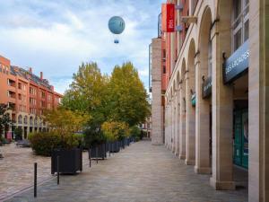 a hot air balloon flying over a street with buildings at ibis Epernay Centre Ville in Épernay