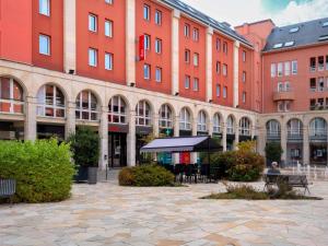 a group of buildings with tables and chairs in a courtyard at ibis Epernay Centre Ville in Épernay +96 photos