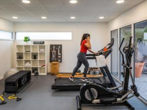 une femme sur un tapis de course dans une salle de sport dans l'établissement ibis Saint-Nazaire - Trignac, à Trignac