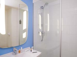 a bathroom with a shower and a sink and a mirror at ibis Saint-Nazaire - Trignac in Saint-Nazaire +98 photos