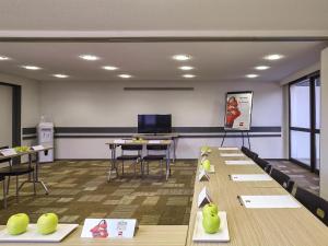 a conference room with tables and chairs and a tv at ibis Saint-Nazaire - Trignac in Trignac +108 photos