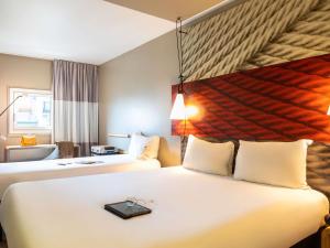 um quarto de hotel com duas camas com uma bandeja em cima em ibis Paris Gare du Nord La Fayette em Paris mais 54 fotografias
