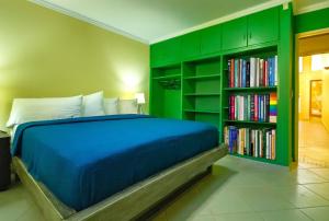a bedroom with a bed and a book shelf with books at Villa Verde · Pool · Guesthouse · Ping Pong in Jan Thiel +48 photos