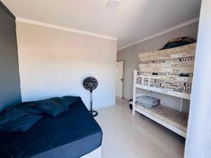 a bedroom with a bed and a fan at Ninho verde ll casa com piscina in Pardinho +10 photos
