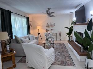 a living room with a white couch and a fireplace at Osprey Coastal Retreat Near Siesta Key in Osprey