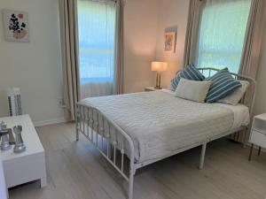 a bedroom with a bed with blue and white pillows at Osprey Coastal Retreat Near Siesta Key in Osprey