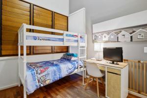 Un dormitorio con una litera y un escritorio con una computadora. en South Shores Villa 22, en Normanville 11 fotos más