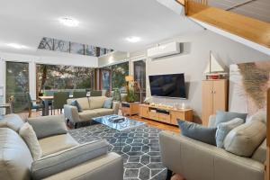 Una sala de estar con sofás y un televisor de pantalla plana. en South Shores Villa 22, en Normanville