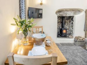 una sala da pranzo con un tavolo in legno con camino di 2 Bed in Llwyngwril 58564 a Llwyngwril