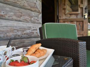 a table with a plate of food and a bowl of strawberries at 1 Bed in Latchley 54164 in Sydenham Damerel +20 photos