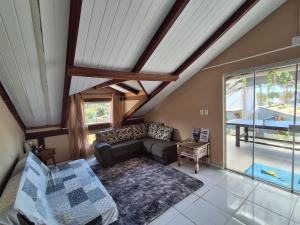 ein Wohnzimmer mit Sofa und Tisch in der Unterkunft Pedra Branca Villa Hostel in Barra Velha