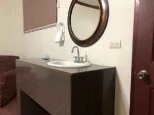 a bathroom with a sink and a mirror on the wall at Hotel oasis suites in Delicias
