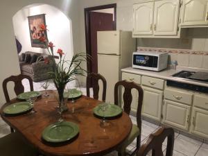 a kitchen with a table with plates and a microwave at Hotel oasis suites in Delicias