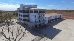 a large white building in the middle of a field at Ello Hotel Cristalina in Cristalina