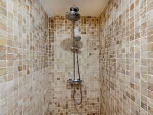 a shower in a tiled bathroom with a shower head at 4 Bed in Cemaes 90258 in Llanfechell +18 photos