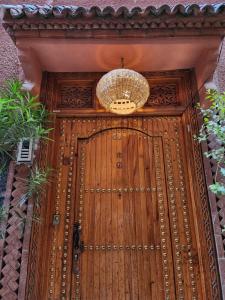 马拉喀什Riad Hostel ADI的木门,上面有吊灯