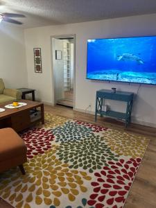 a living room with a large tv on the wall at Entire Vacation home blocks to the Strip, ARTS Dist, & Main Street Sleeps up to 8 in Las Vegas