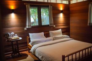 a bedroom with a bed and a window and a table at Belongas Bay Lodge LOMBOK in Blongas