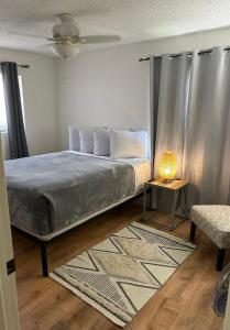a bedroom with a bed and a table with a lamp at Entire Vacation home blocks to the Strip, ARTS Dist, & Main Street Sleeps up to 8 in Las Vegas