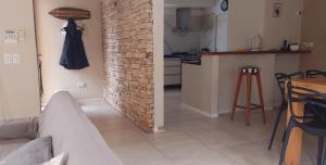 a living room with a brick wall and a kitchen at Casa de Flia in Villa Gesell