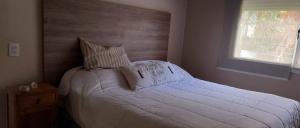 a bedroom with a large bed with white sheets and pillows at Casa de Flia in Villa Gesell +9 photos