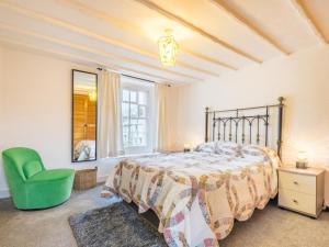 una camera da letto con un letto e una sedia verde di 2 Bed in Bassenthwaite SZ415 a Bassenthwaite