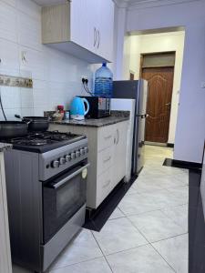 a kitchen with a stove and a refrigerator at Luxx Homes #Unit A in Ruiru