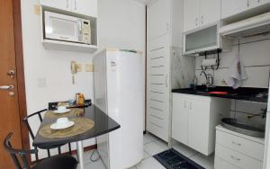 ブラジリアにあるAconchegante proxima ao parque e ao setor hospitalarのテーブルと冷蔵庫のある小さなキッチン +14枚の写真