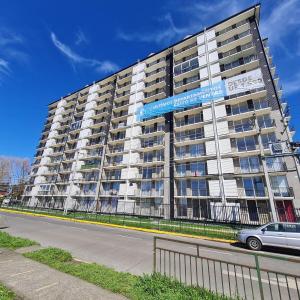 ein großes Mehrfamilienhaus am Straßenrand in der Unterkunft Departamento 3 dormitorios en villarica in Villarrica
