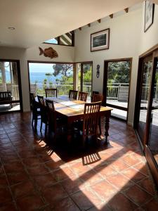 a dining room with a wooden table and chairs at Whananaki Hideaway in Whananaki