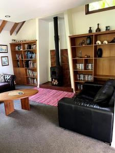 a living room with a couch and a wood stove at Whananaki Hideaway in Whananaki +50 photos