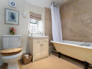 a bathroom with a tub and a toilet and a sink at 5 Bed in Betws-y-Coed 55987 in Pentrefoelas +21 photos