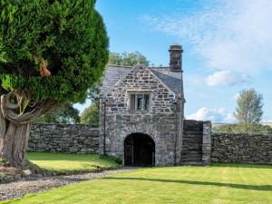 an old stone house with a stone wall at 5 Bed in Betws-y-Coed 55987 in Pentrefoelas