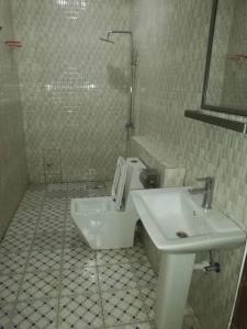 a white bathroom with a sink and a toilet at SPLENDID APARTMENTs in Mbarra Kunku +11 photos